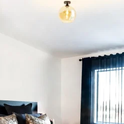 Mat zwarte plafondlamp met amber glazen bol 30 cm